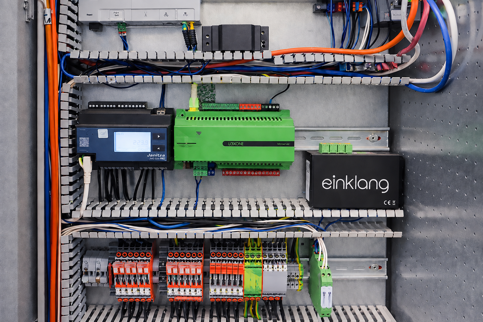 Elektronischer Schaltschrank mit grünen und schwarzen Logikmodulen und vielen Kabeln.