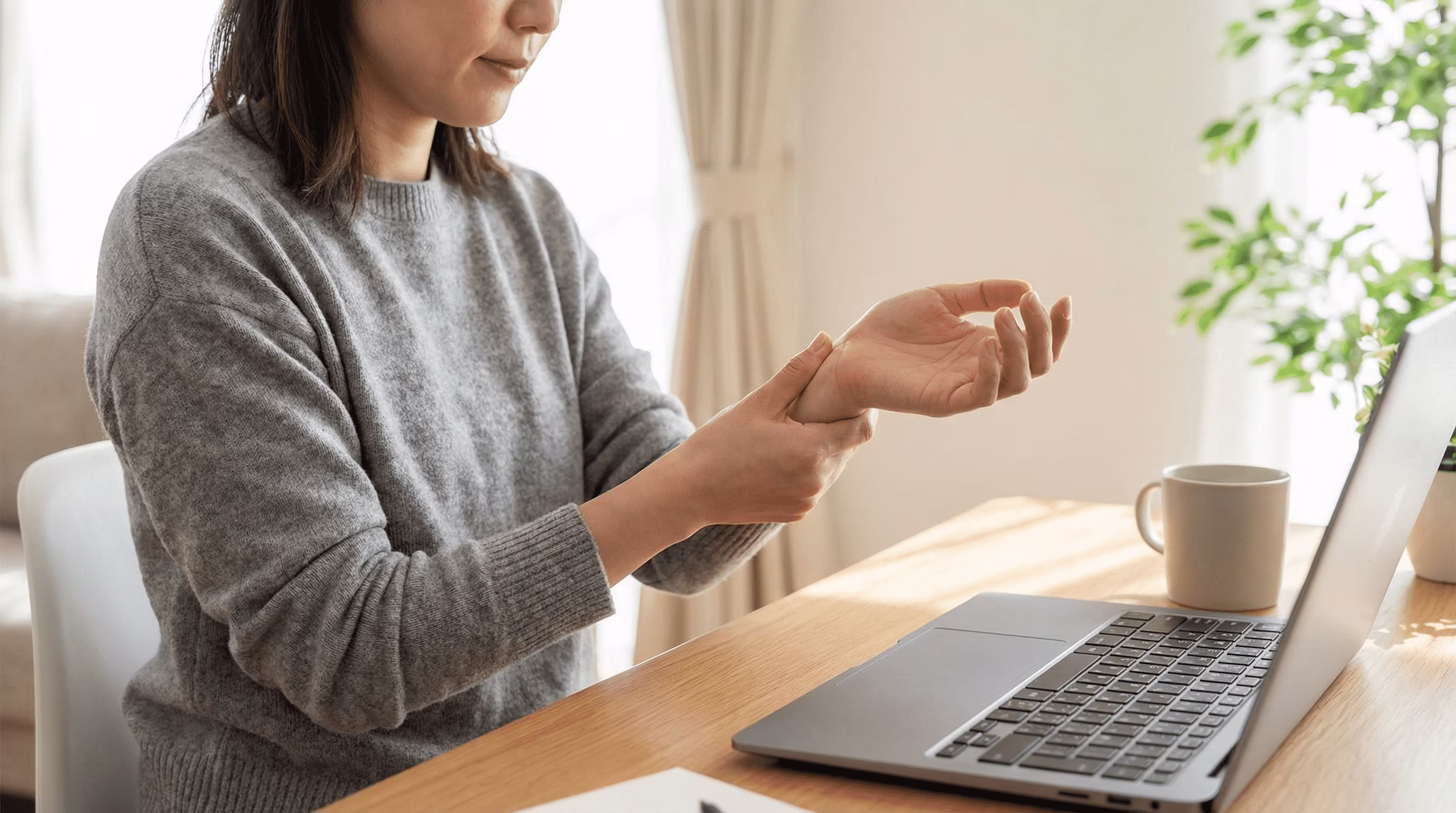 Woman gently stretching wrist with palm up to relieve ulnar-side tension.