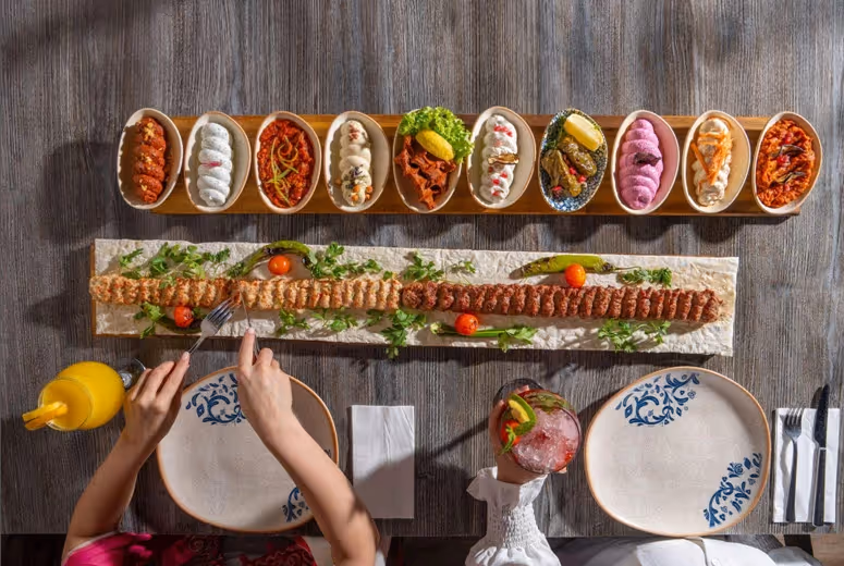 Traditional Turkish dinner dining experience in Dubai featuring colorful mezzes, grilled kebabs and family-style presentation at Turkish Village