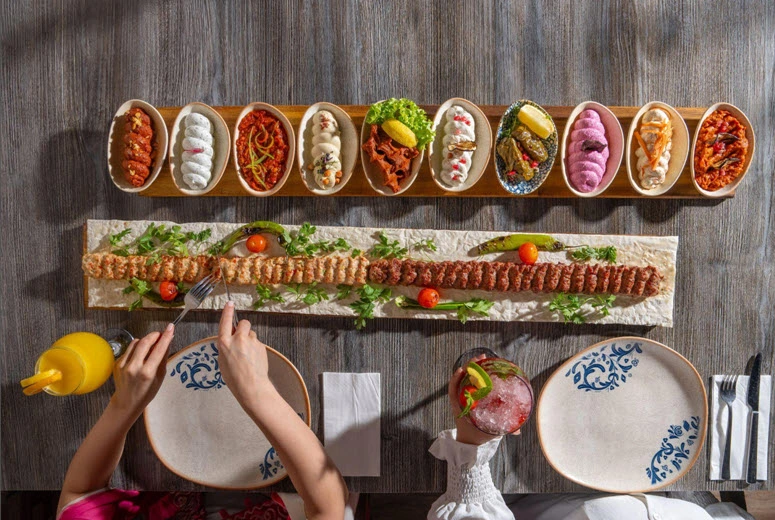 Traditional Turkish dinner dining experience in Dubai featuring colorful mezzes, grilled kebabs and family-style presentation at Turkish Village