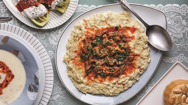 Overhead shot of hünkar beğendi — a smoky eggplant purée topped with diced stewed meat in tomato sauce and fresh parsley