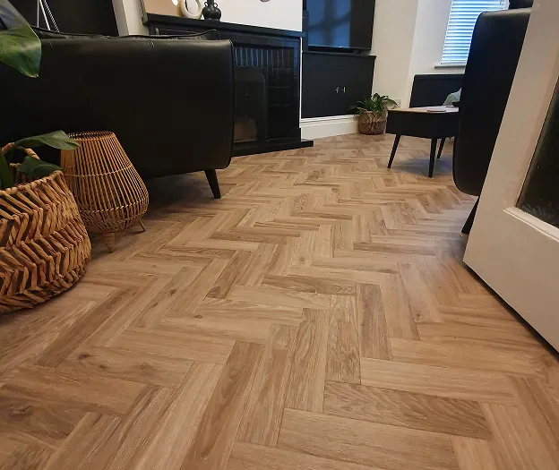 A living room with a wooden floor and black chairs.