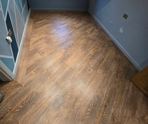 A dark wooden floor in a room with blue walls.