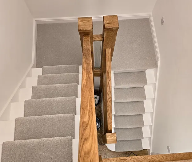 A staircase with carpeted steps leading up to a second floor.