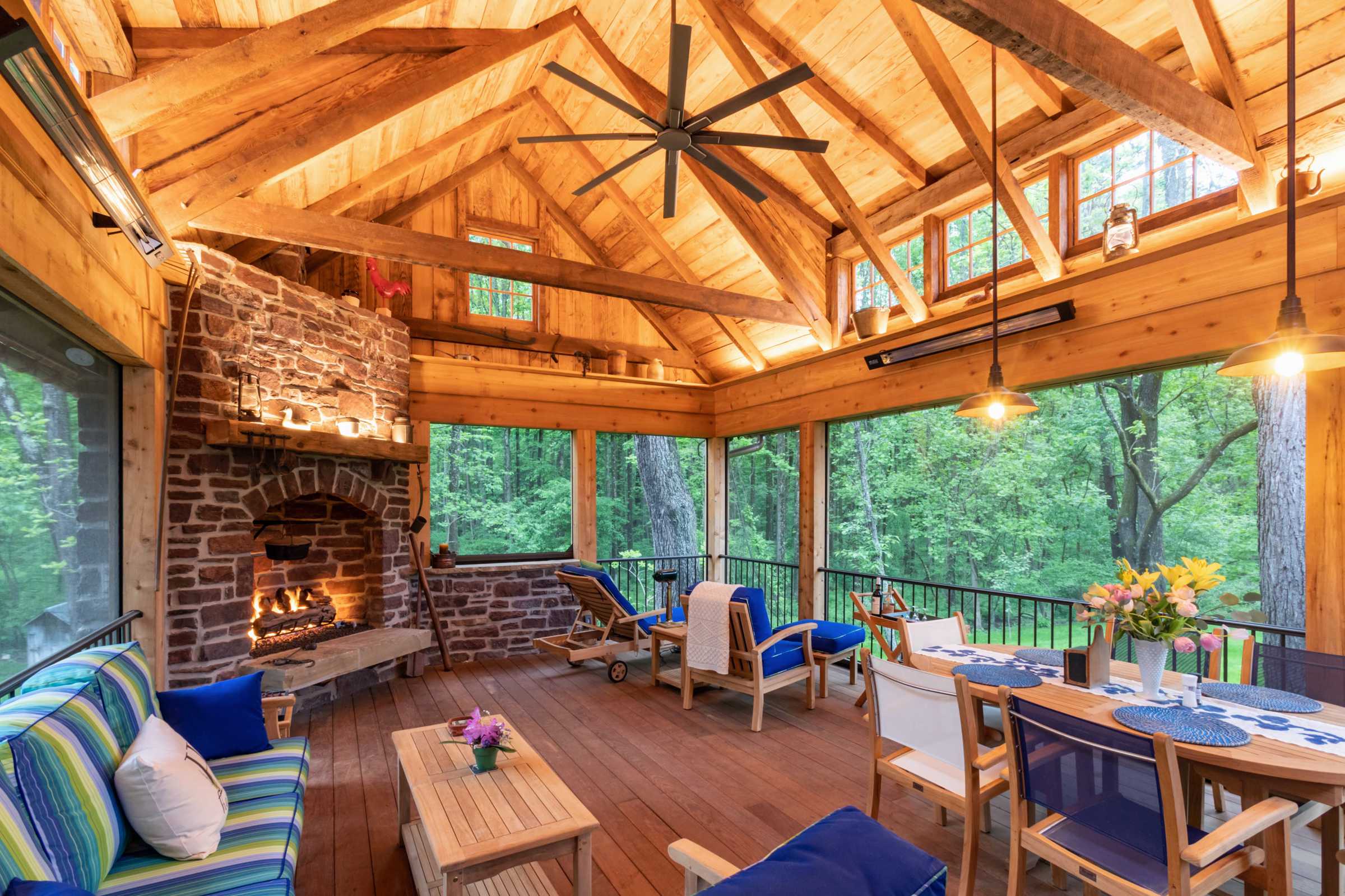 Interior of Timber Frame Pavilion with Screened in Living Space and Stone Fireplace.