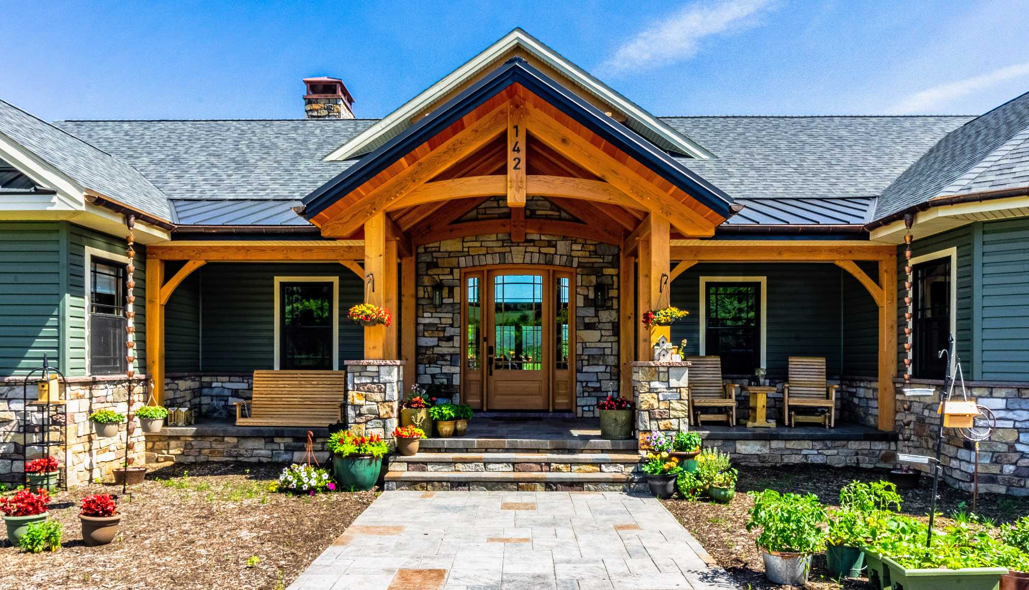 Modern timber frame home with a large deck. Custom arched timber trusses add extra design flair.