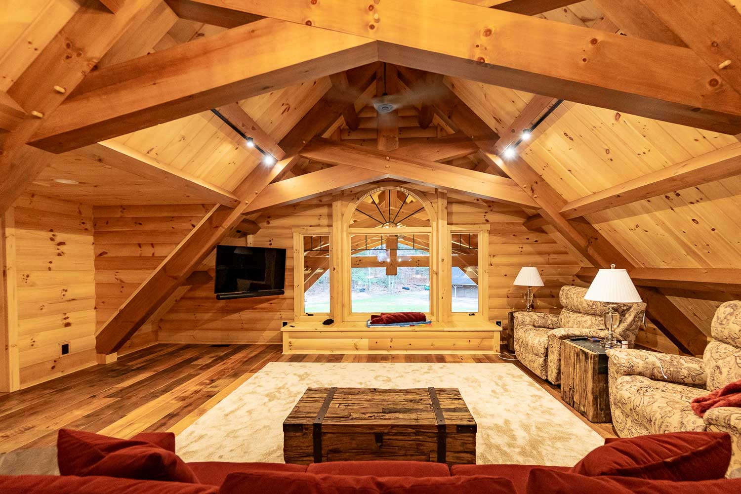 Large loft sitting area with large and unique timber frame trusses.