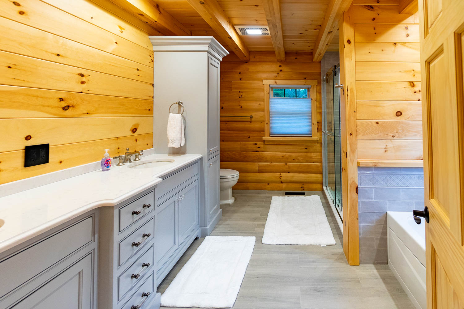 Large bathroom with a perfect combination of painted cabinets and the natural wood.