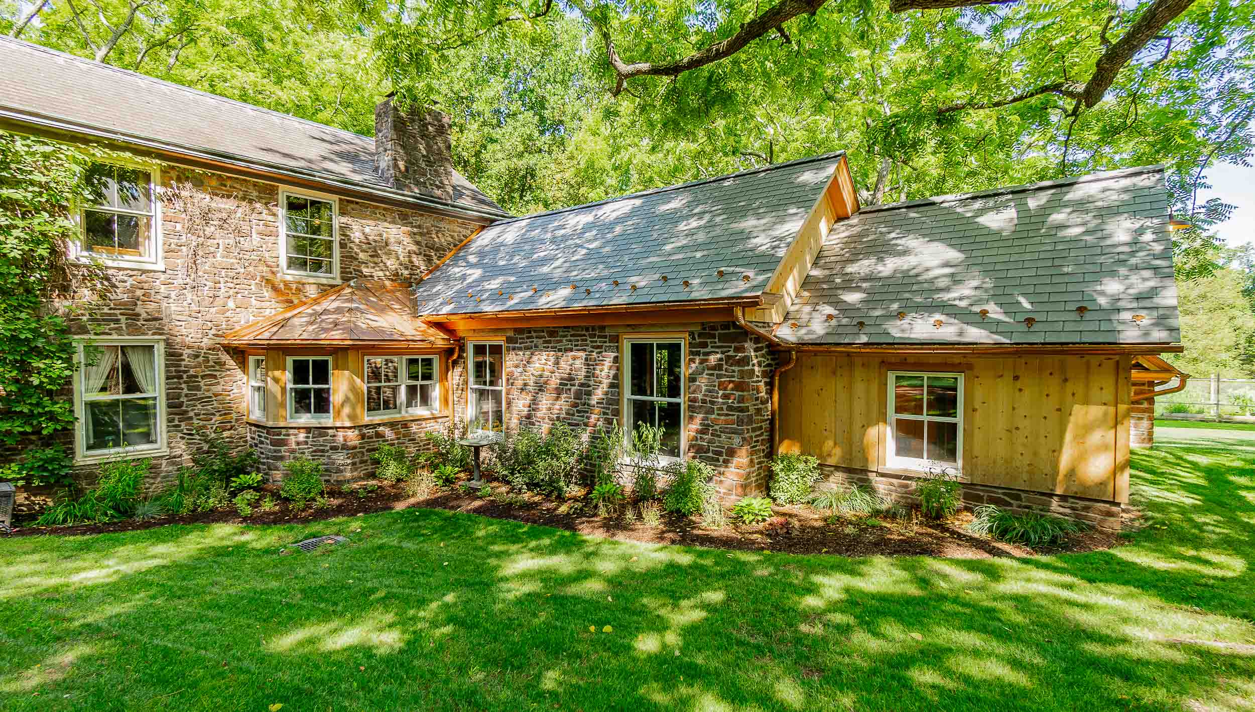 Addition with Natural Stone, Spanish Cedar Trim, Cedar Siding, Copper Standing Seam and Vinyl Slate Roof.