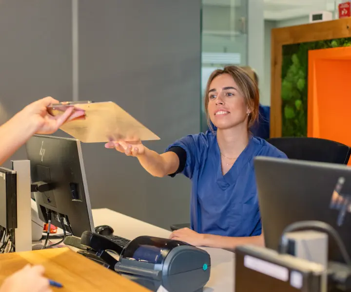 Medewerker van MKA Kennemer & Meer helpt een patiënt aan de receptie