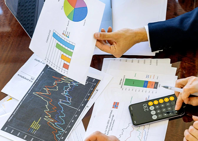 Hojas y dispositivos electrónicos mostrando gráficas financieras