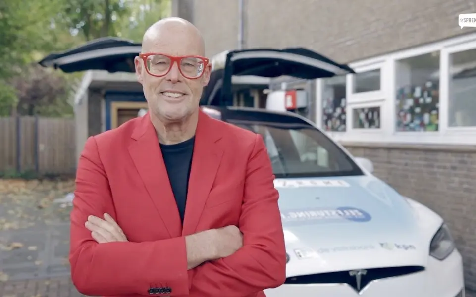 guy in red jacket smiling with folded arms