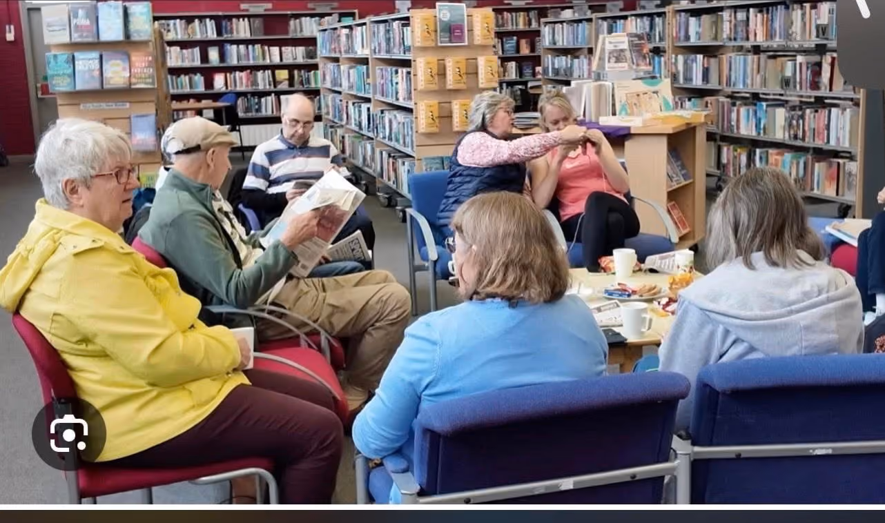 A group of elderly people meeting in a library