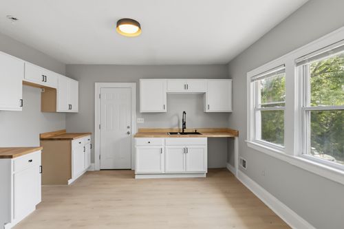 After — remodeled kitchen with white cabinets and butcher block counters — Manzil