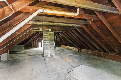 Before — unfinished attic framing before insulation and drywall — Manzil