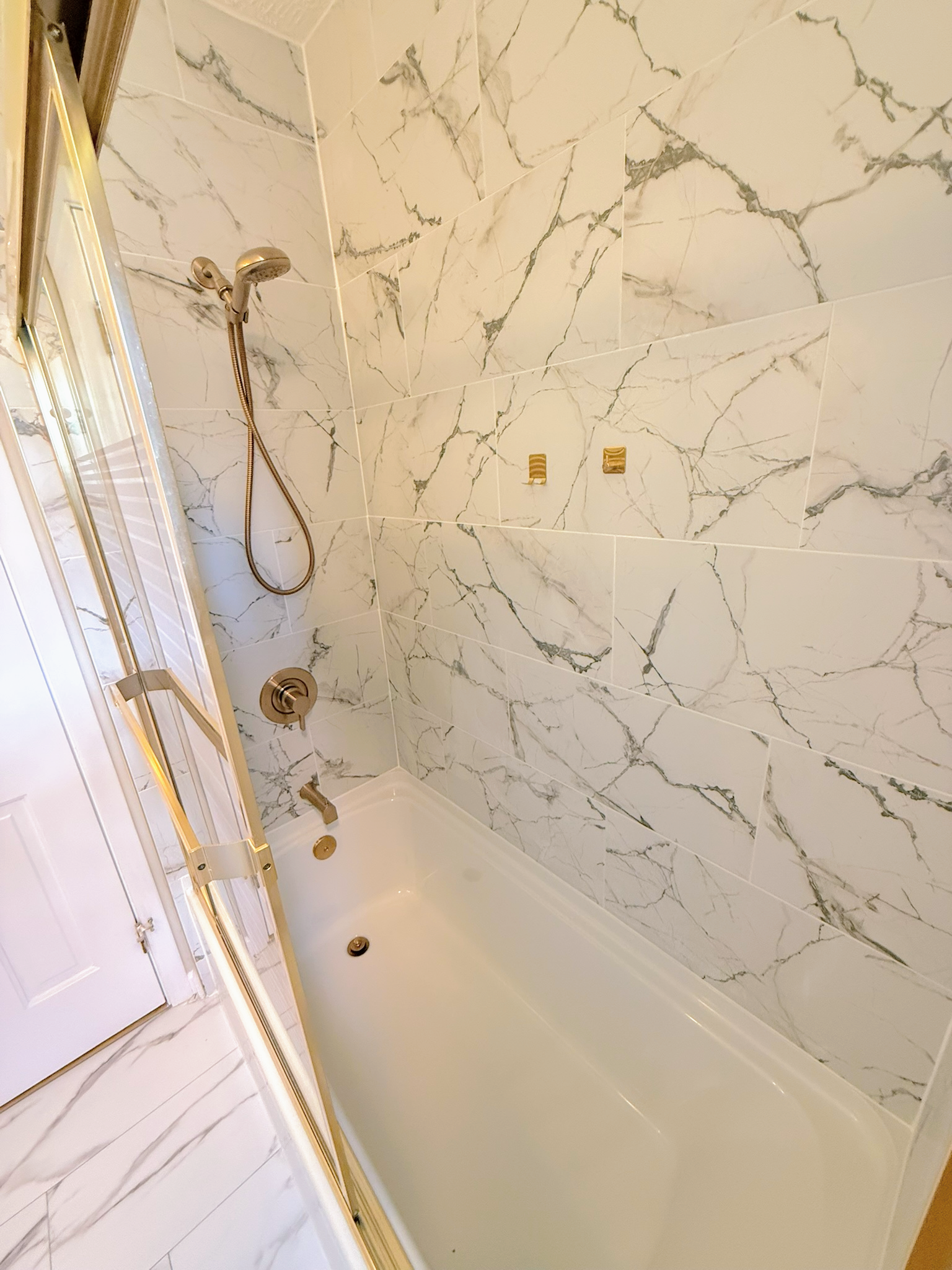 Updated full bathroom with marble-look tile in a Cleveland ranch