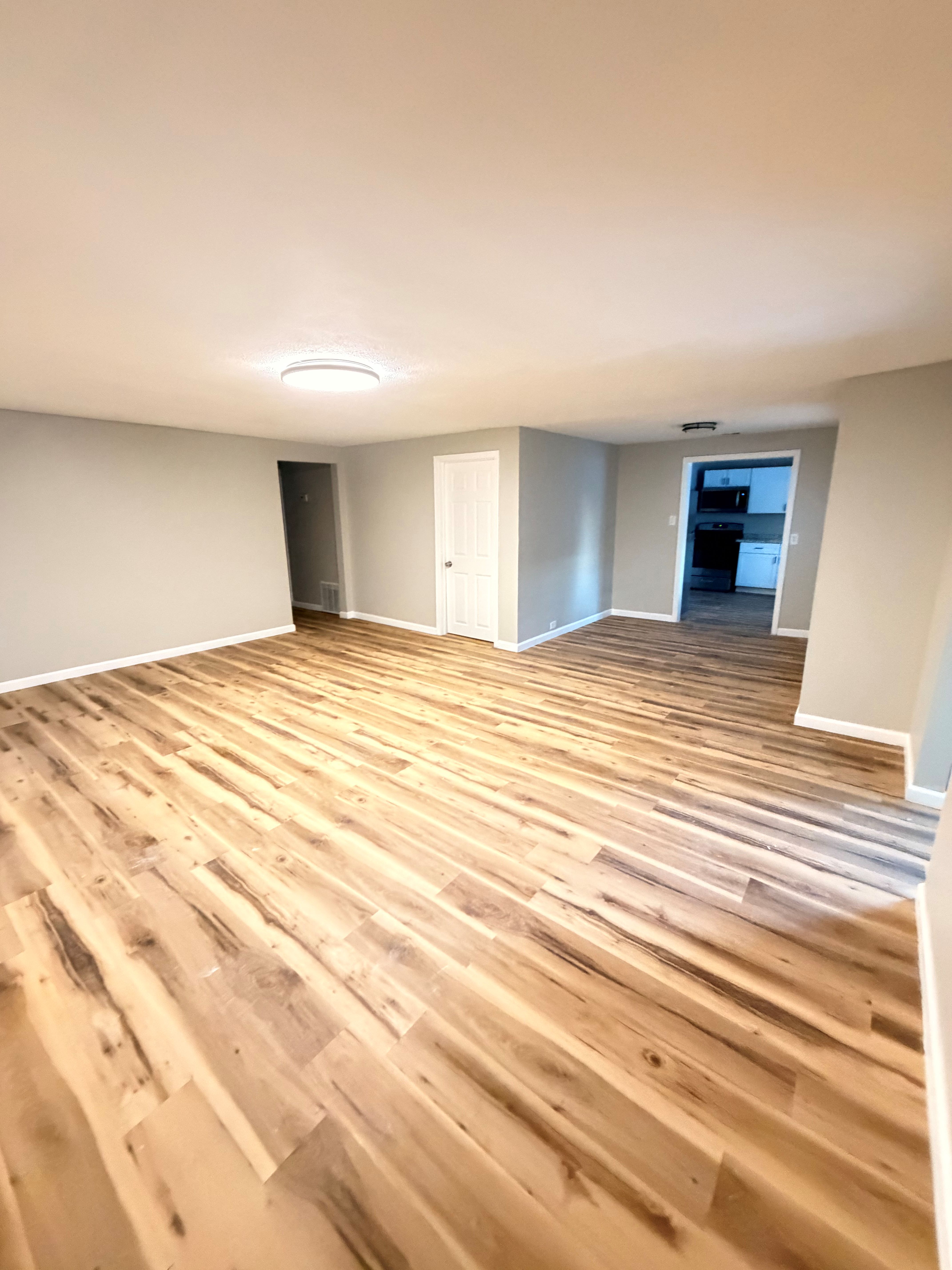After — open living room with new flooring in North Ridgeville, OH — Manzil Renovation