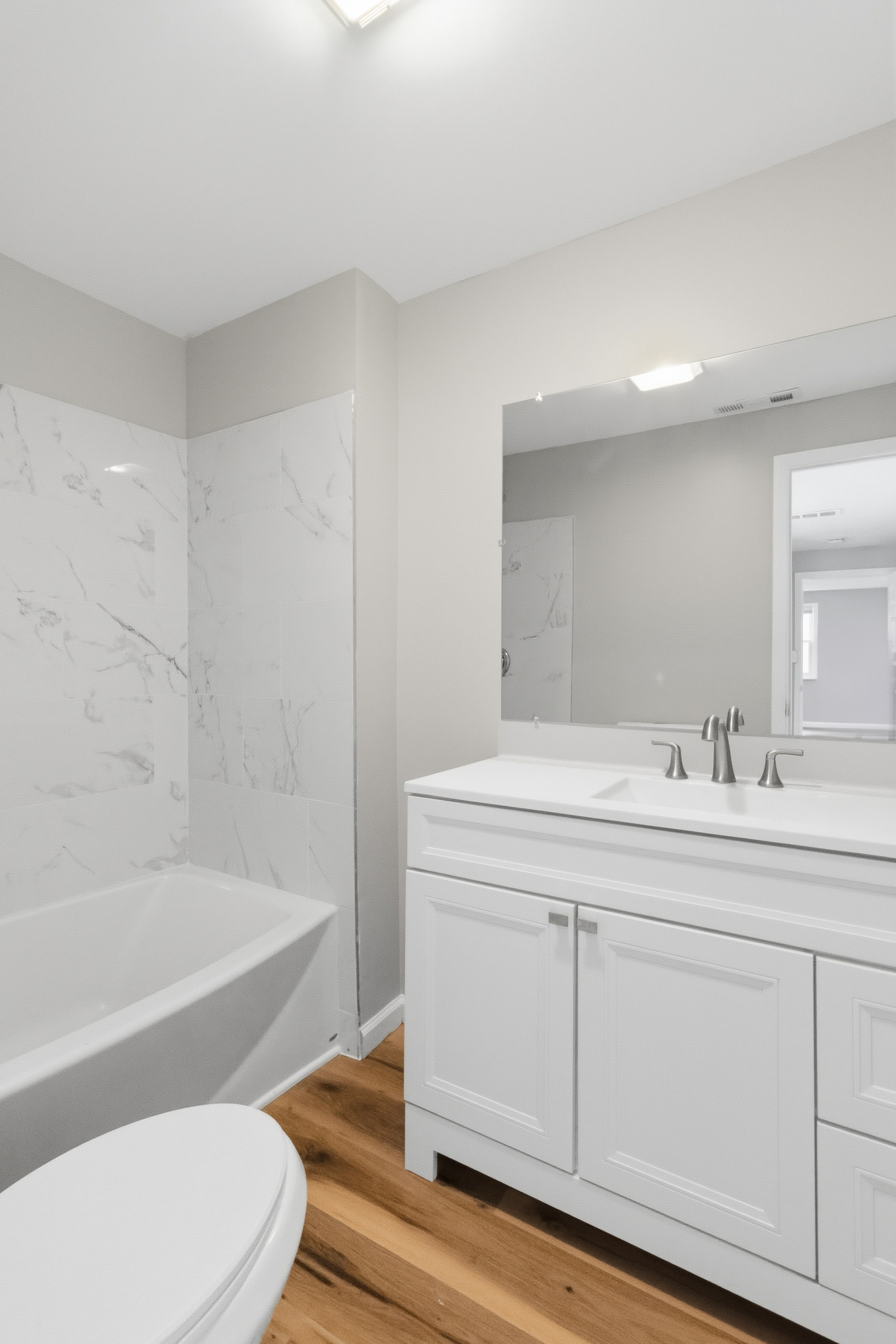 After — second full bathroom with tub and marble-look tile in North Ridgeville, OH — Manzil Renovation