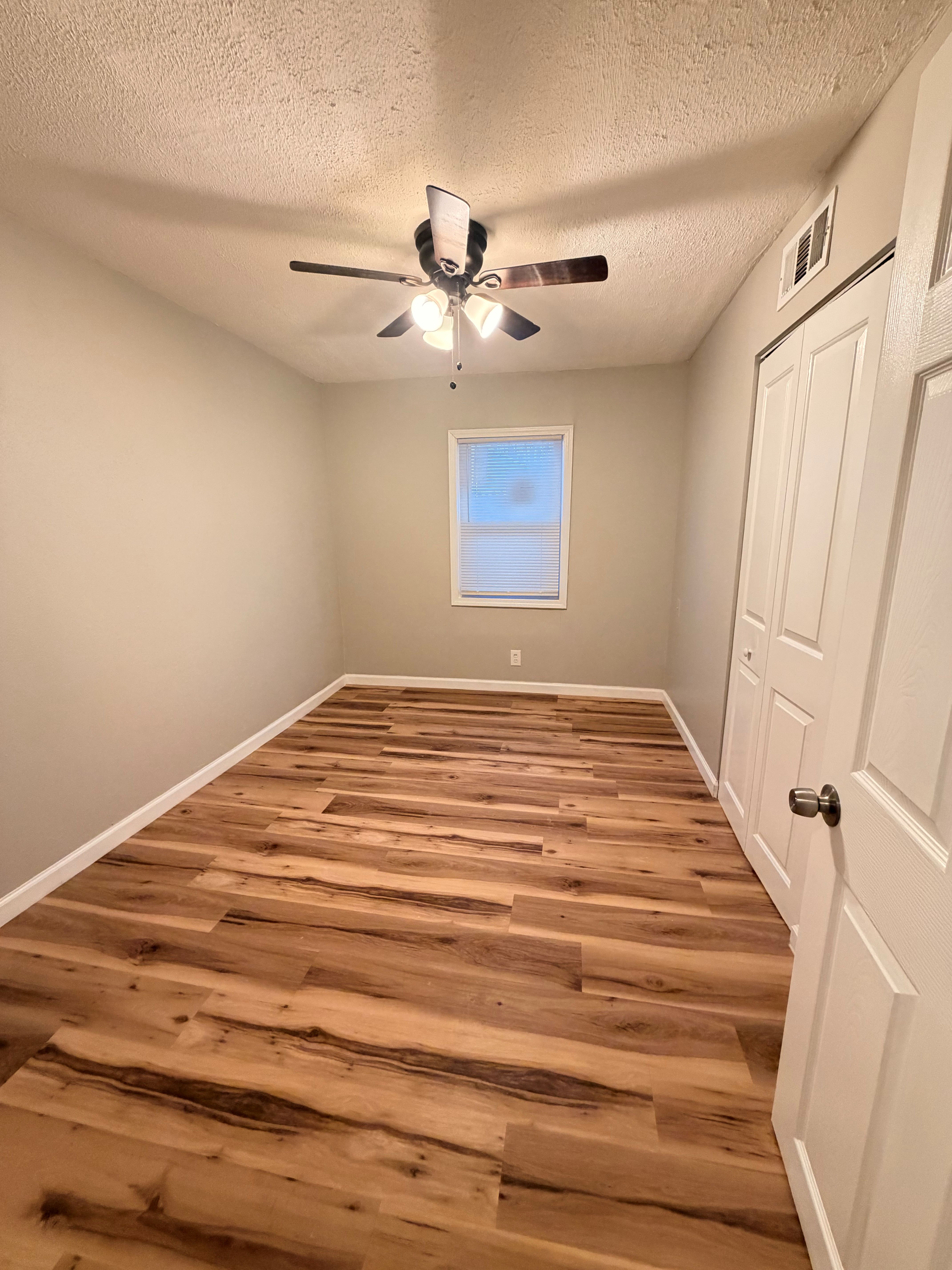 After — renovated bedroom with new flooring and ceiling fan in North Ridgeville, OH — Manzil Renovation