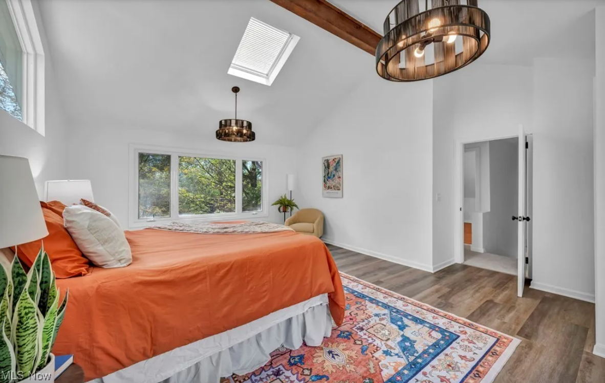 After — vaulted primary bedroom with beams & chandelier in Brecksville, OH — Manzil Renovation