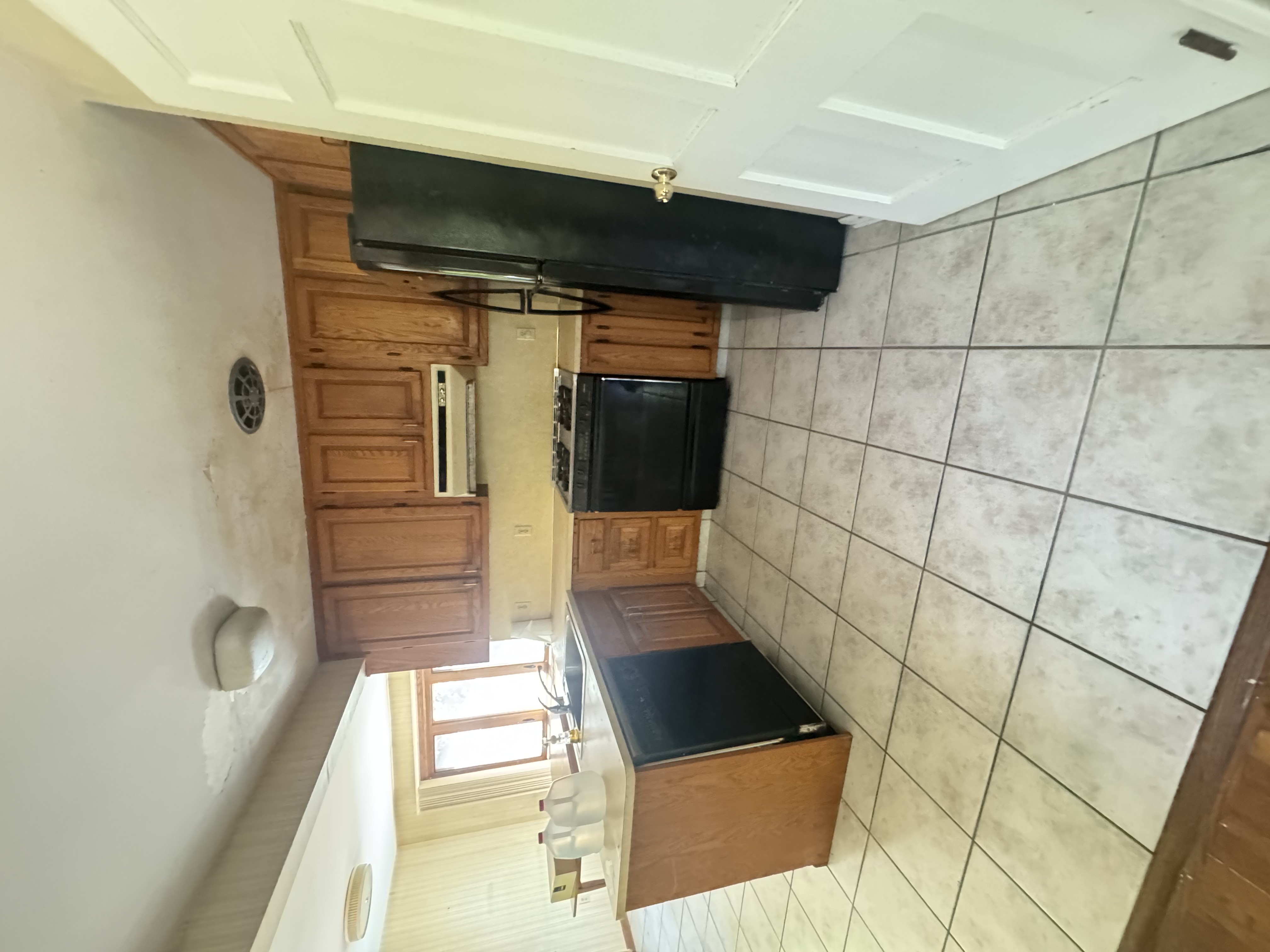 Before — kitchen with oak cabinets and black appliances in Brecksville, OH — Manzil Renovation