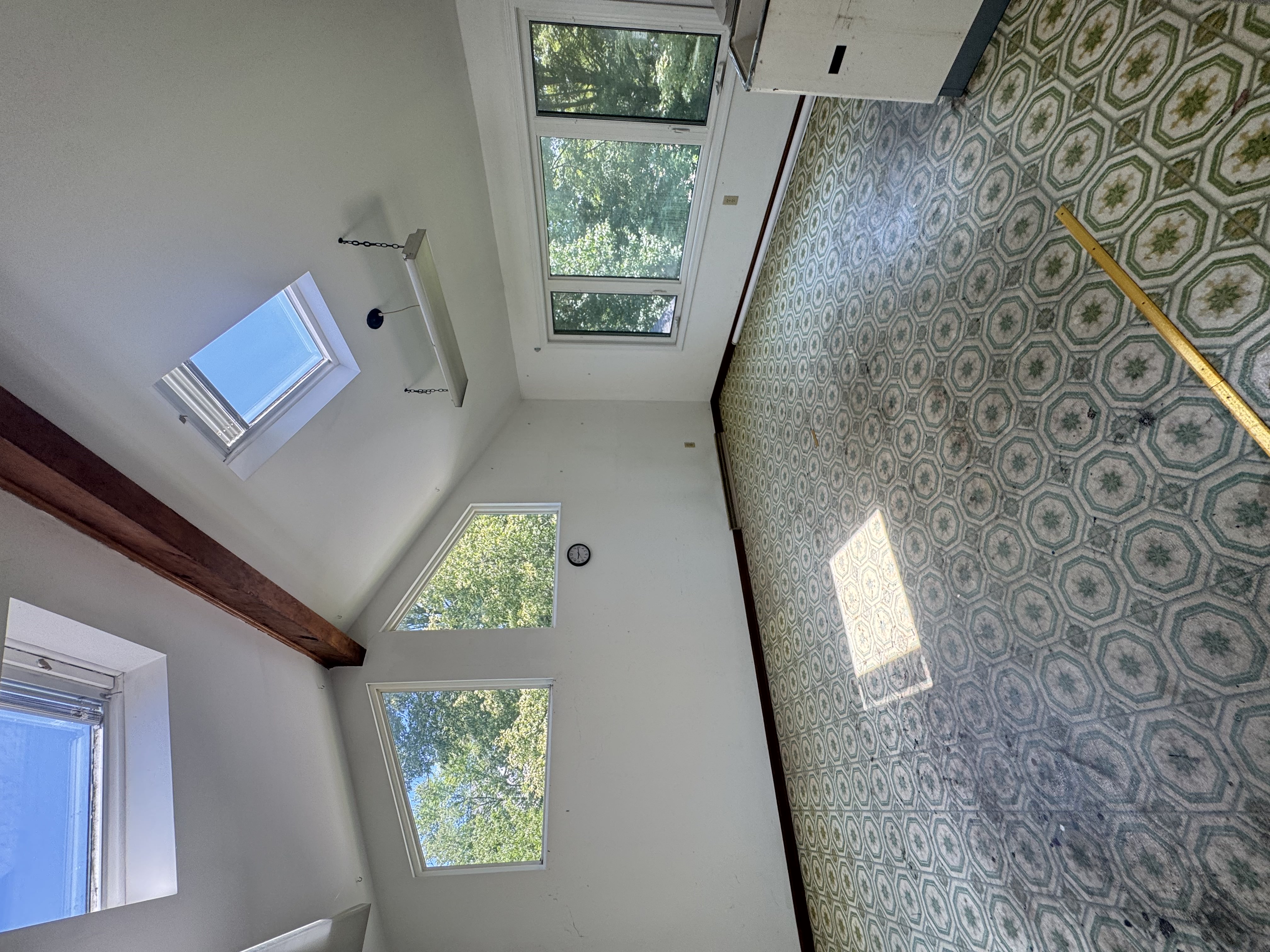 Before — vaulted room with green vinyl floor in Brecksville, OH — Manzil Renovation