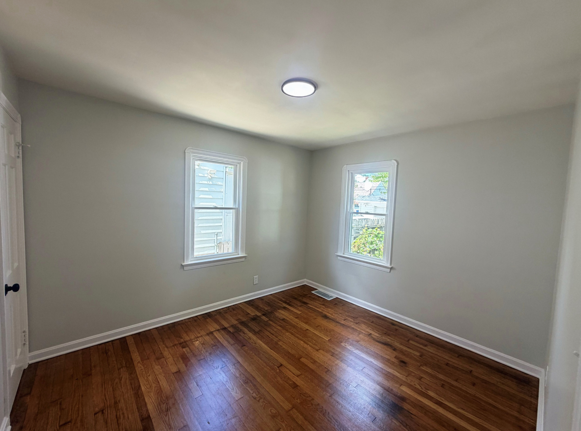 Bedroom with refinished hardwood floors and fresh paint, Wayland Ave Cleveland renovation