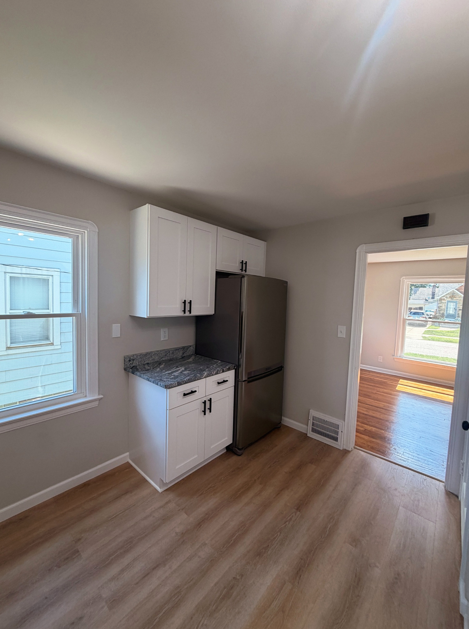 Refrigerator nook and white cabinetry in the new kitchen, Wayland Ave Cleveland renovation