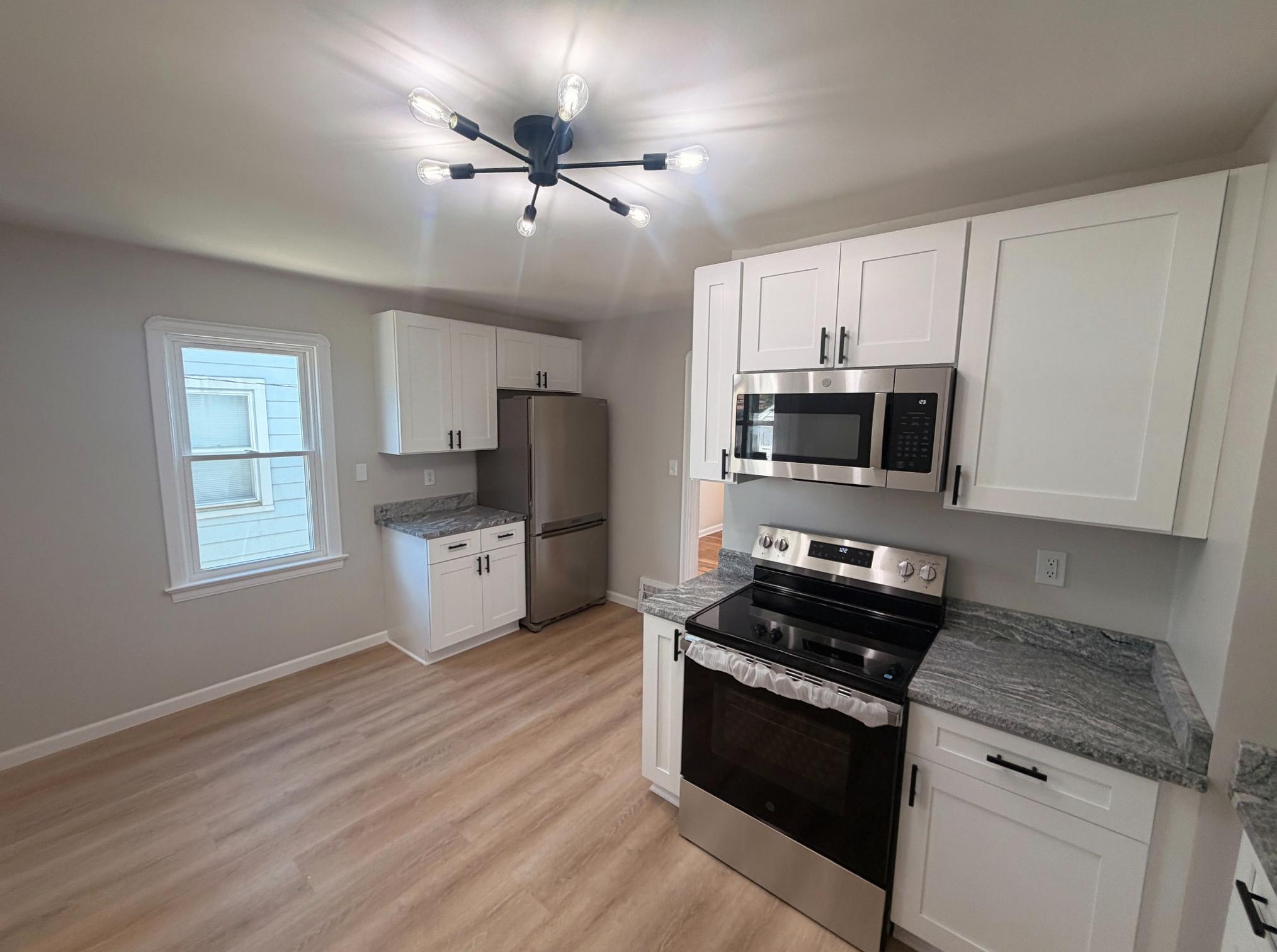 New kitchen with stainless refrigerator and white cabinets, Wayland Ave Cleveland renovation