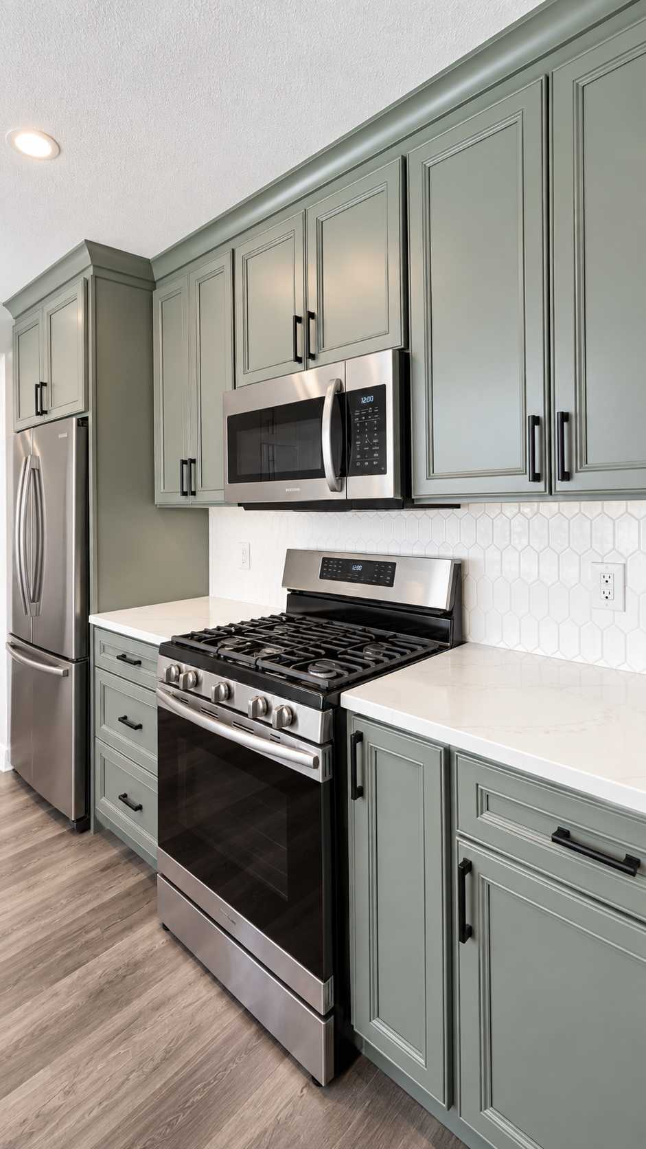 Sage-green cabinets, stainless gas range and microwave in a custom Cleveland kitchen remodel