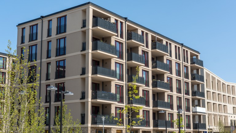 A large apartment building featuring multiple balconies on its exterior.