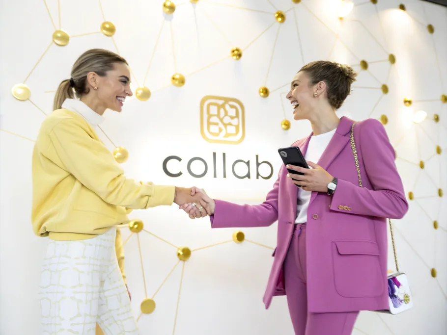 Two stylish individuals shaking hands in a modern studio, symbolizing partnership in a clothing brand social media strategy.