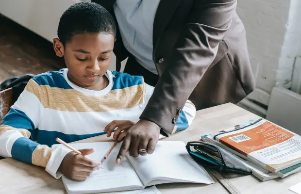 A student and teacher looking and pointing at a notebook