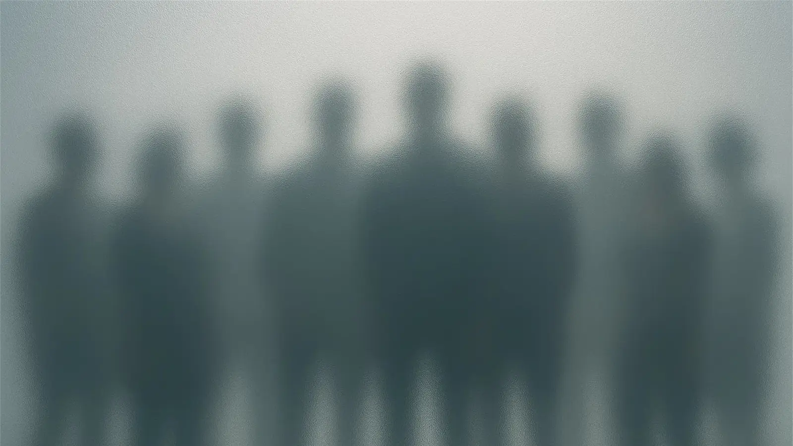 A group of businesspeople obscured by frosted glass.