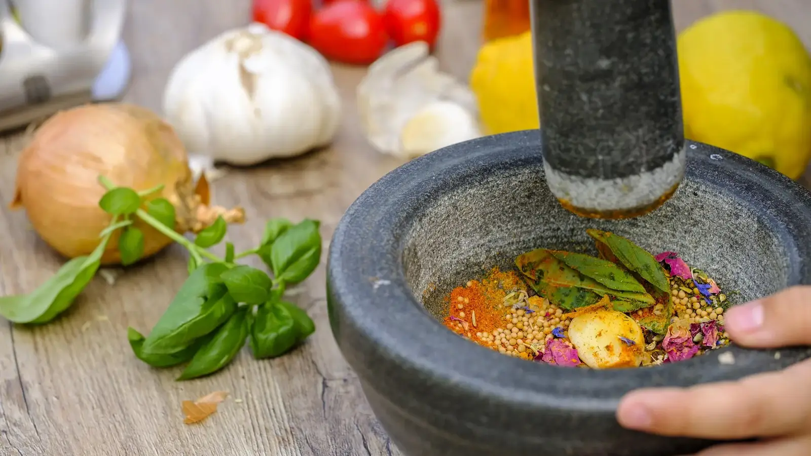 A mortar and pestle with various spices being mulled.