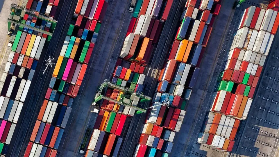 Shipping containers stacked in a port's cargo area.