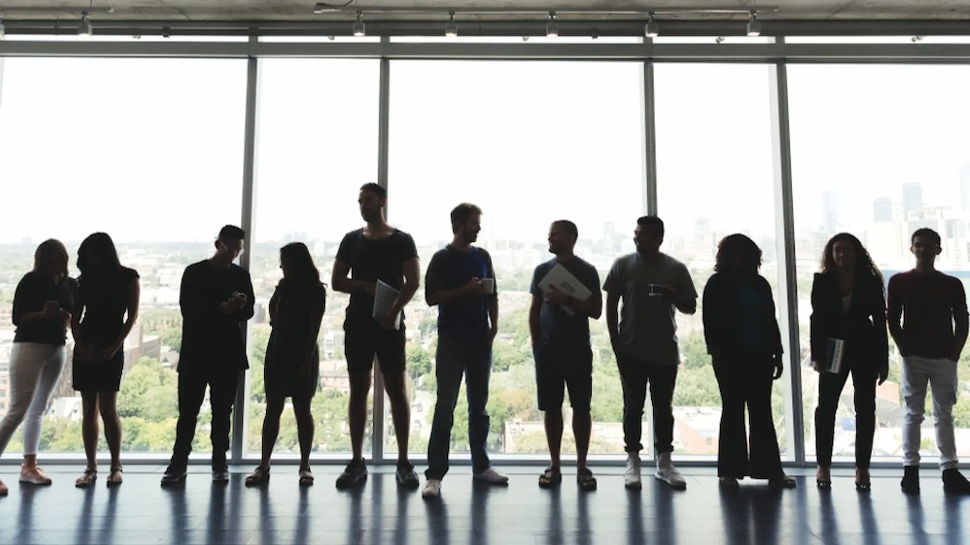 Silhouettes of varying sizes against a large window.