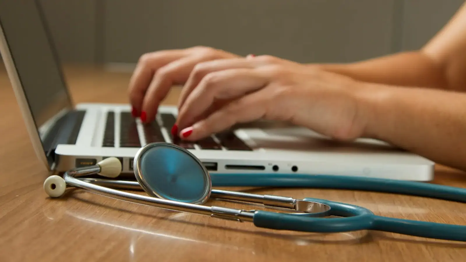 A stethoscope next to a laptop.