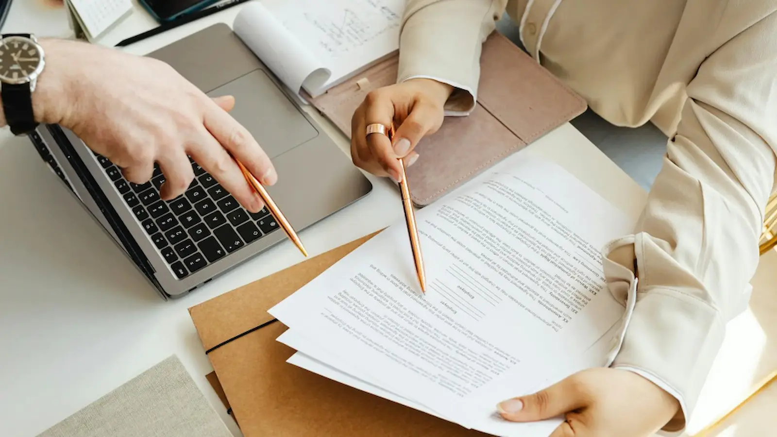 Two people pointing to a contract.
