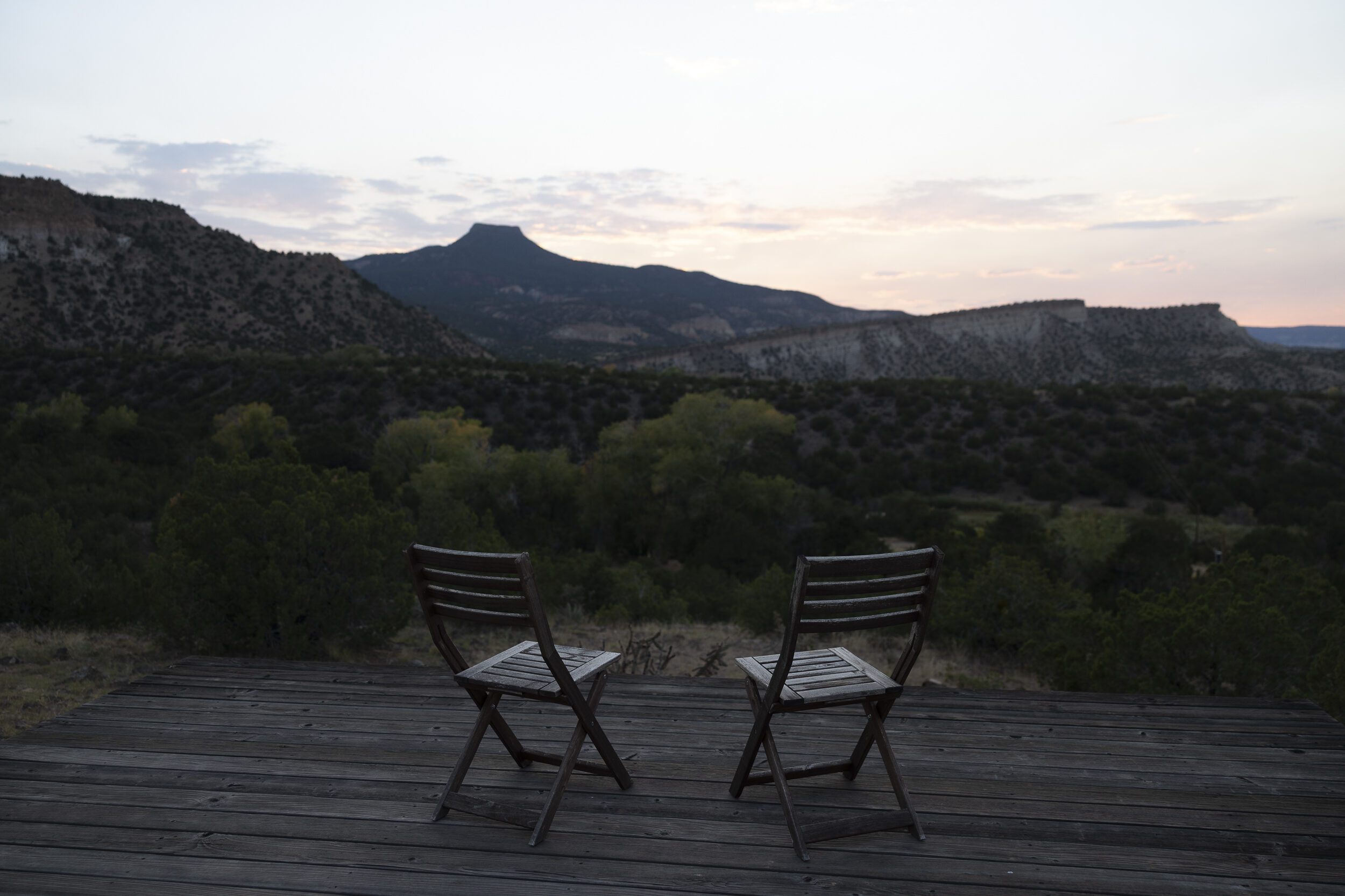 Two chairs on a deck facing the mountains at the LAND