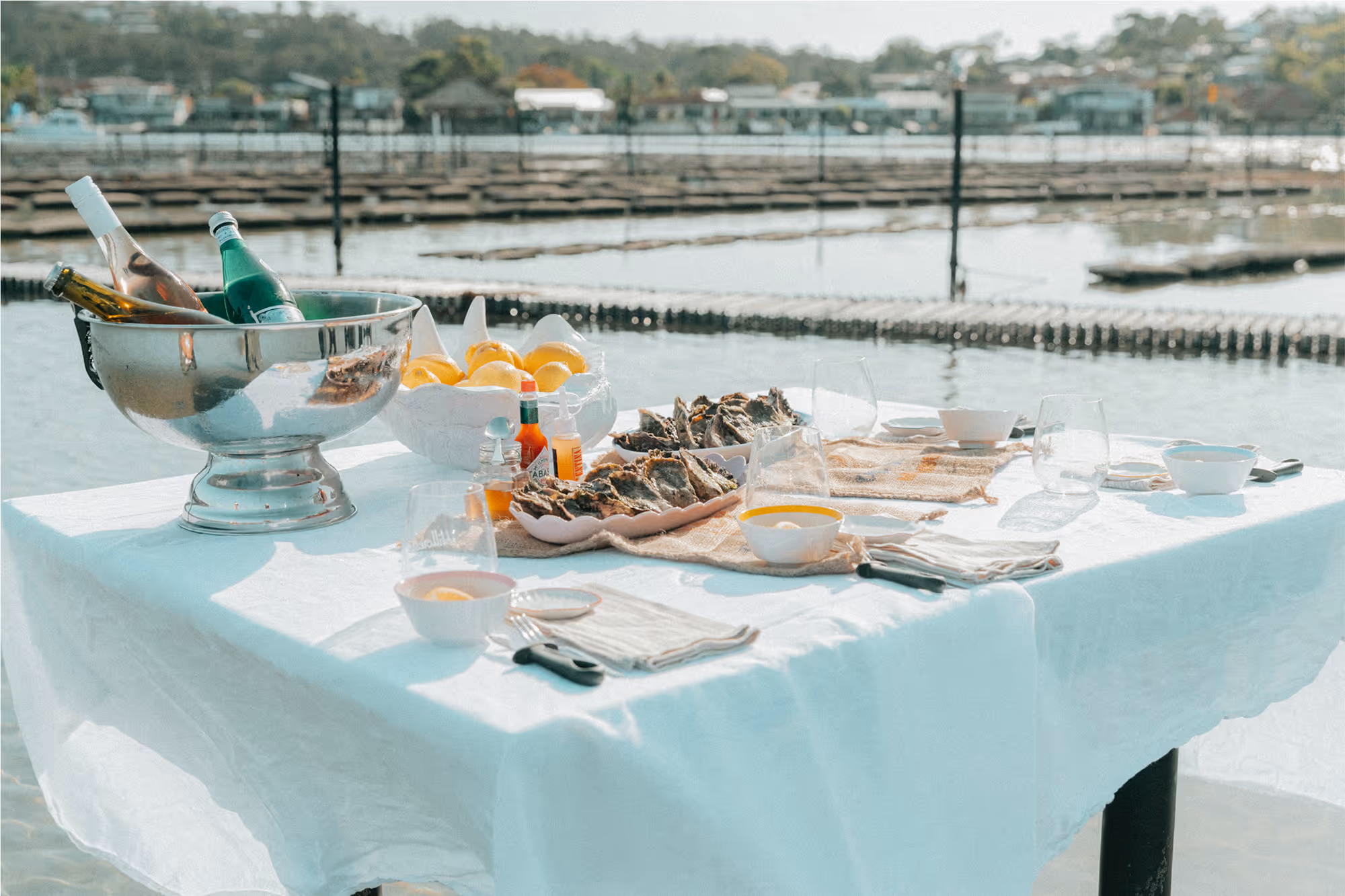 Fresh oysters and a bottle of champagne arranged on a square table