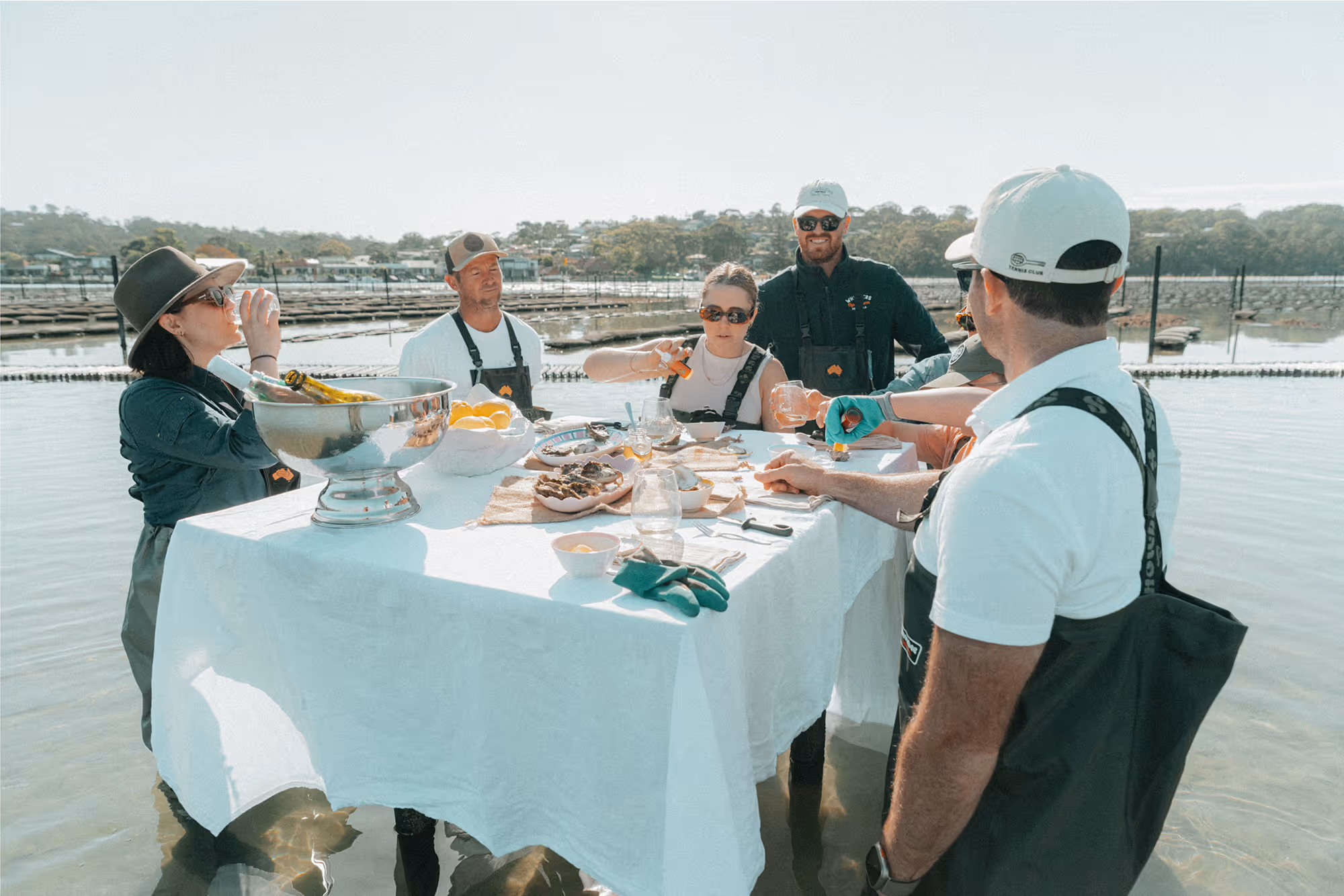 A group of friends enjoying fresh oysters and champagne at a table