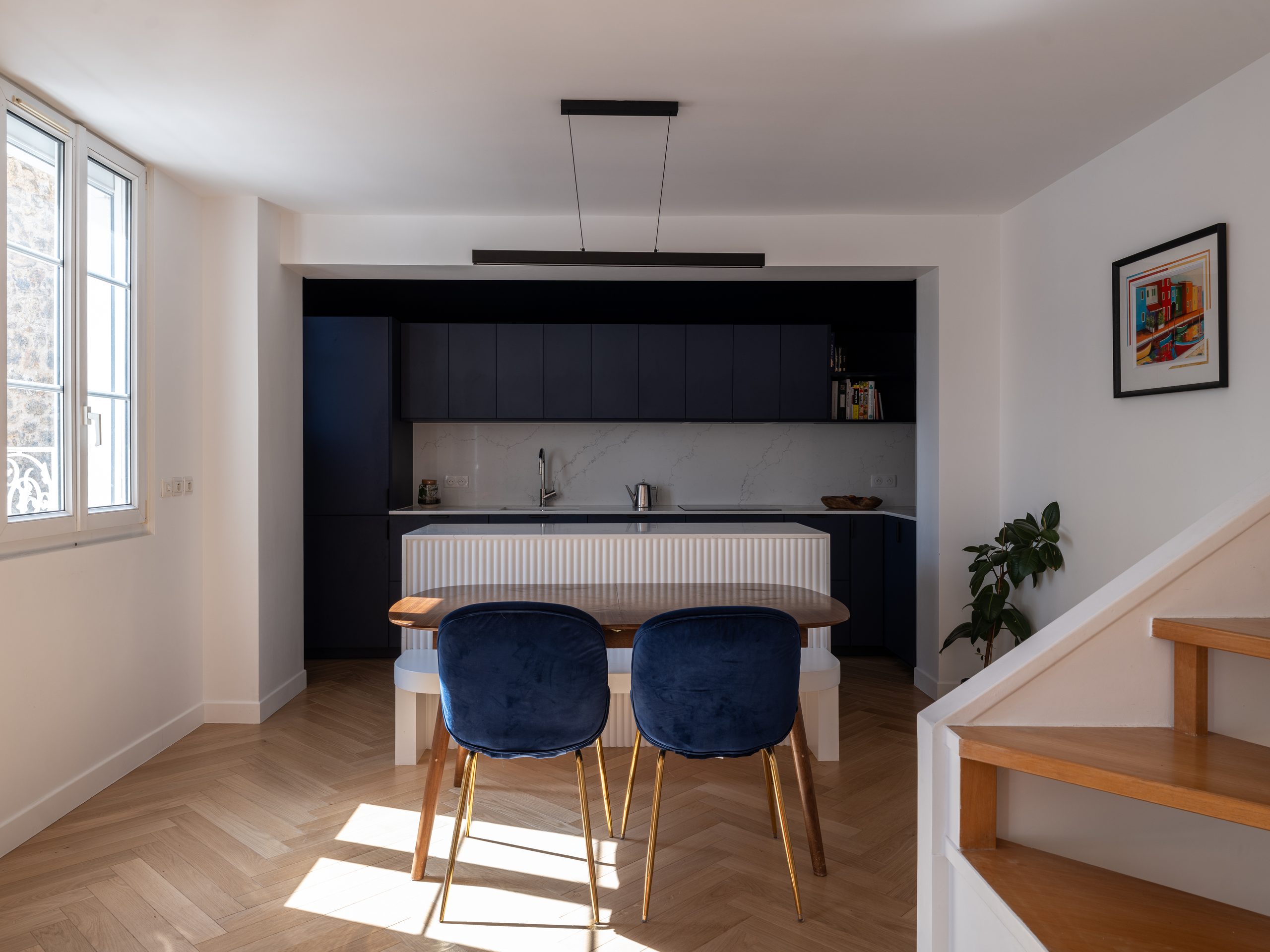 Oïkos Architectes — Surélévation et rénovation d'une maison à Colombes — séjour ouvert sur la cuisine et la salle à manger, escalier hélicoïdal en bois