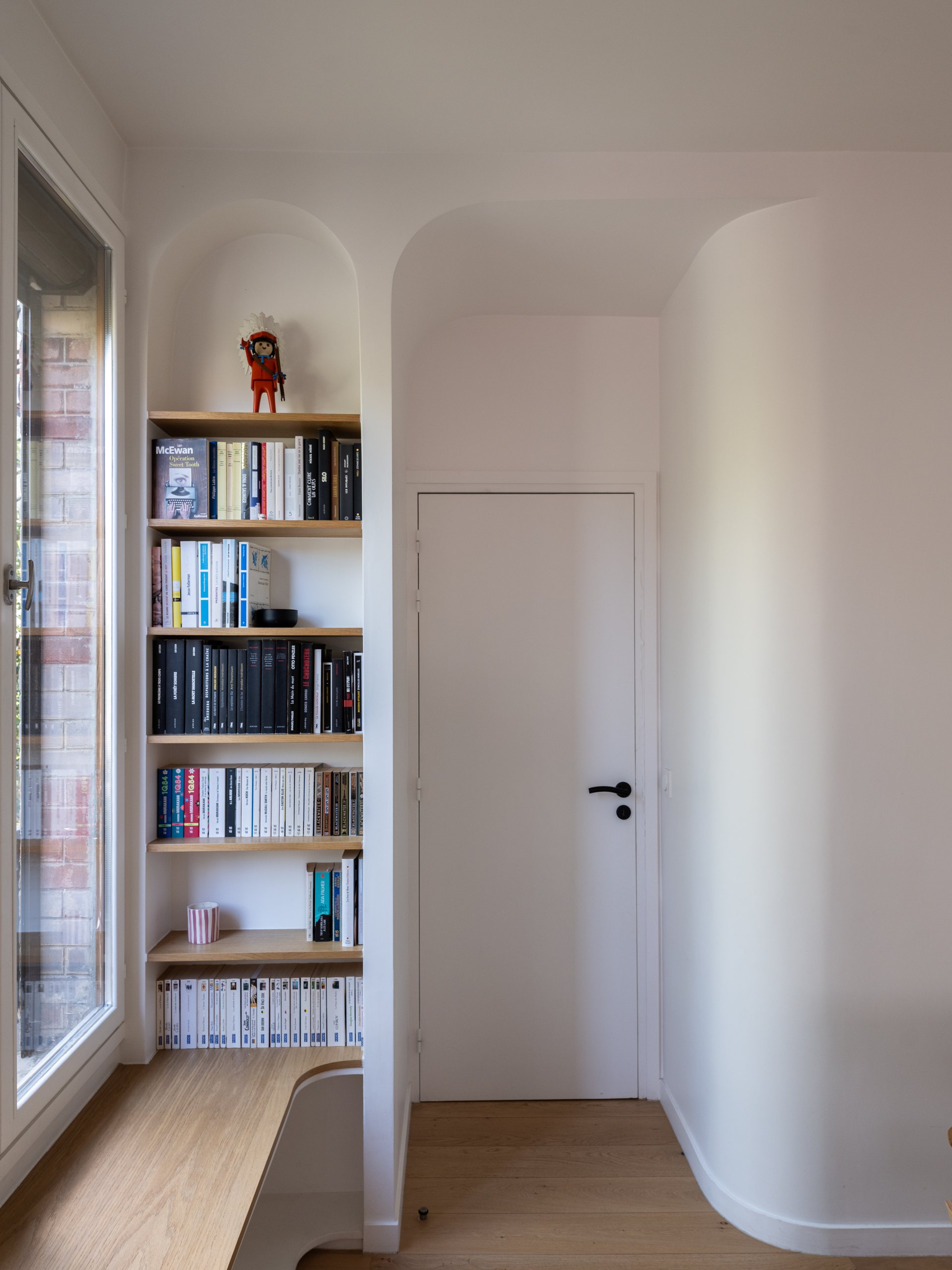 Oïkos Architectes — Maison à Colombes — la bibliothèque et les volumes courbes de la pièce à vivre
