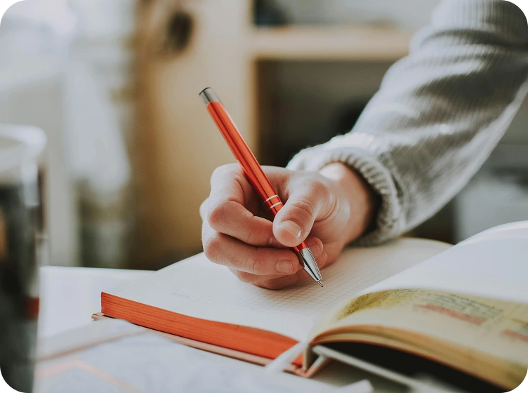 Hand, die in ein Journal schreibt