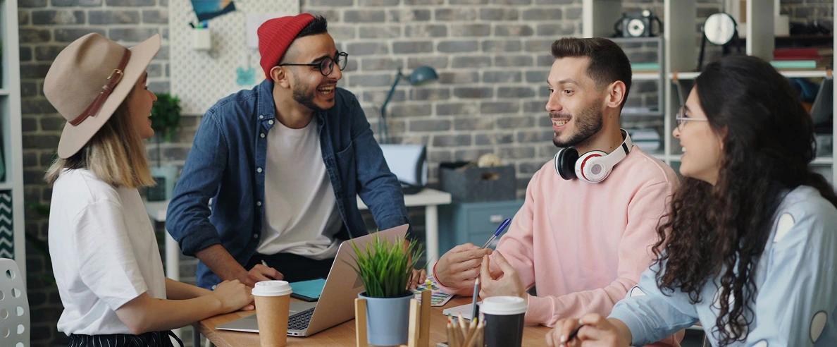 4 Personen lachen im Büro miteinander