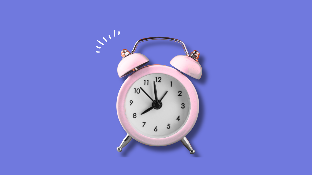 Pink alarm clock on purple background