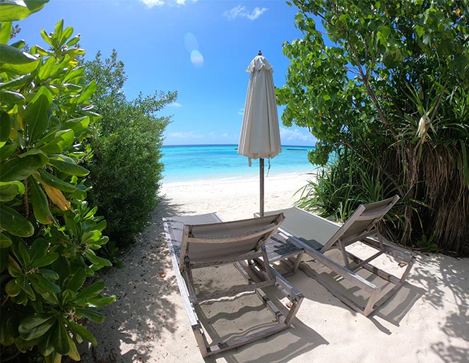 Sun loungers on the beach overlooking the turquoise lagoon