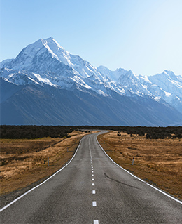 Road leading towards snow capped mountains
