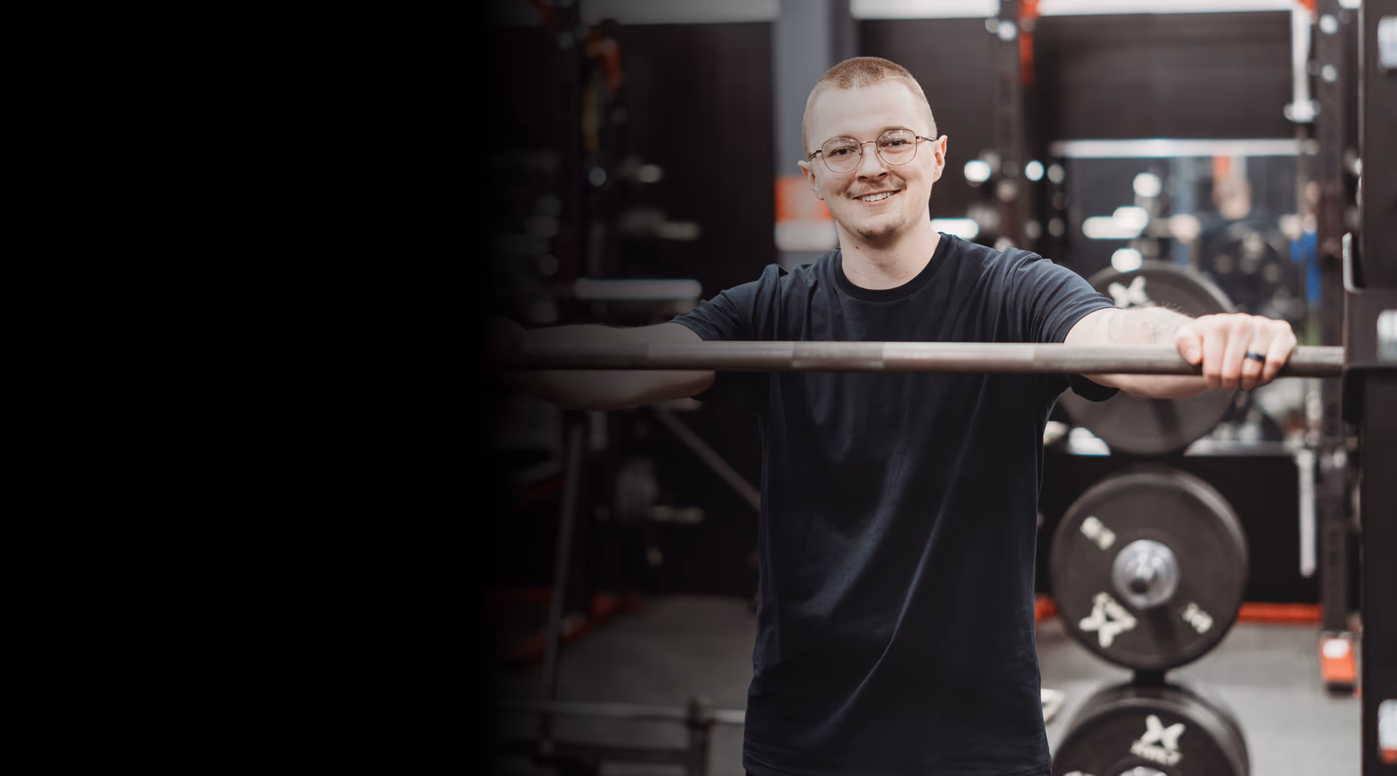 A man standing next to a bar in a gym.